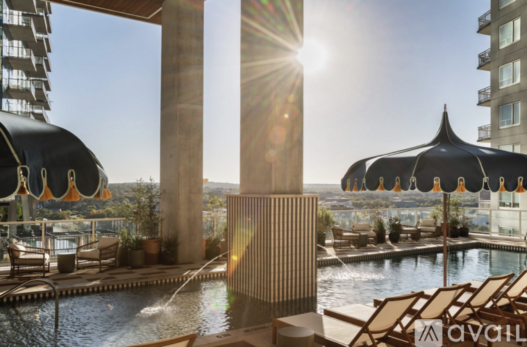 A sunny day at a poolside with sunlight streaming through a gap in the buildings.