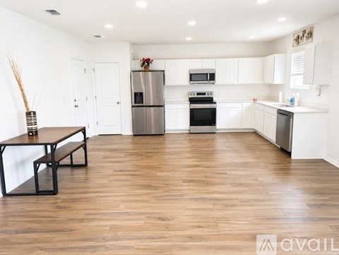 A kitchen with white cabinets and a wooden table.
