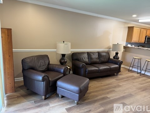 A living room with brown leather furniture and two lamps.