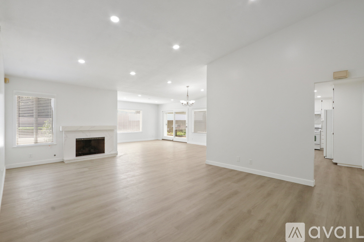 A spacious living room with a fireplace and hardwood floors.