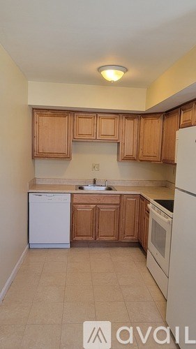 A kitchen with wooden cabinets and white appliances.