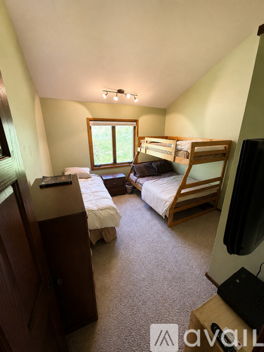 A bedroom with two beds and a television.