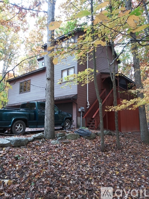 A house with a green truck parked in front of it.