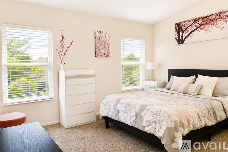 A bedroom with a large bed and two windows.
