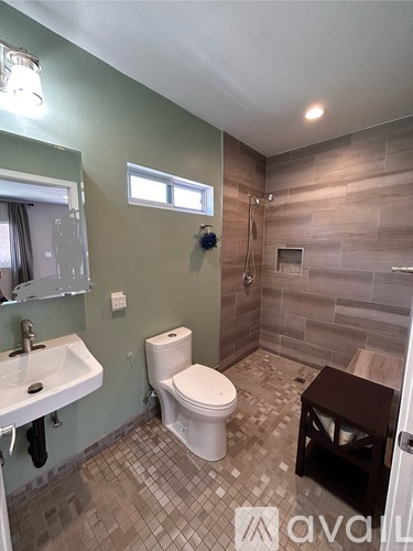 A bathroom with a toilet, sink, and tiled floor.