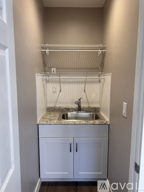 A small white kitchen with a sink and cabinets.