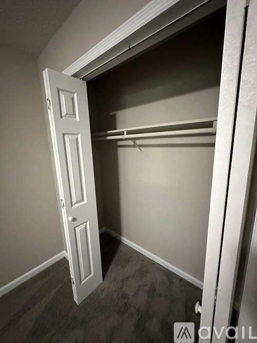 A white door is open to a dark hallway.