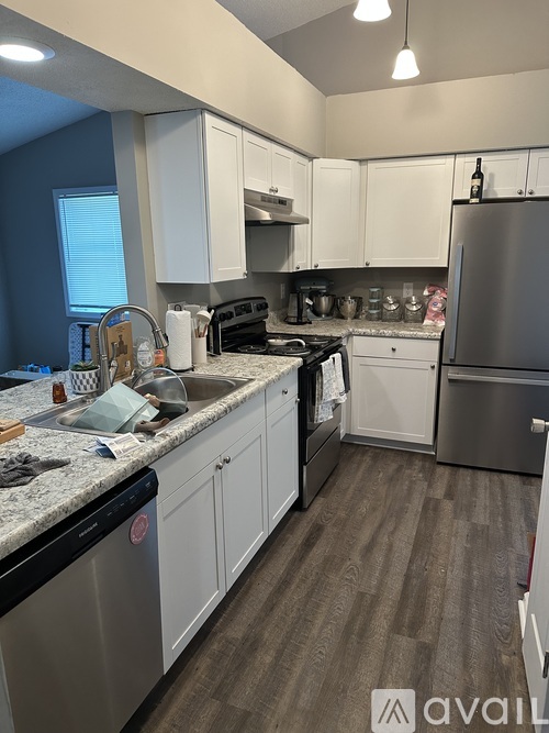 A kitchen with white cabinets and a stainless steel refrigerator.