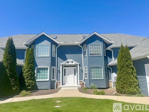 A blue house with a white door and windows.