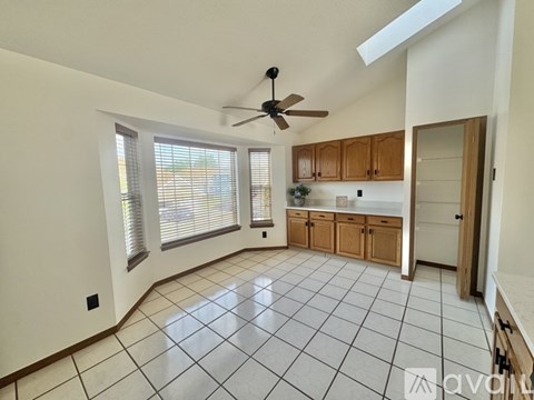 A spacious kitchen with wooden cabinets and a ceiling fan.
