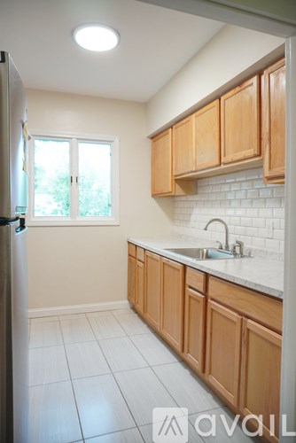 A kitchen with wooden cabinets and a white fridge.