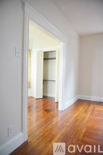 A room with a wooden floor and a white wall.
