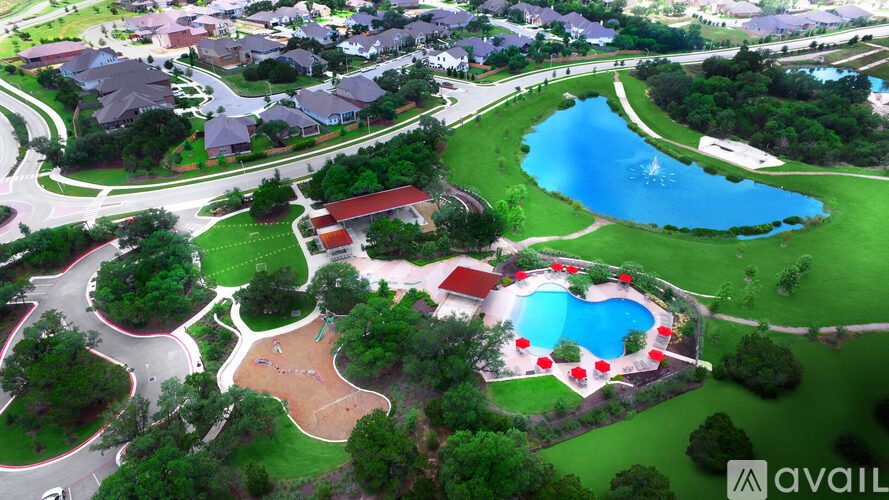 A bird's eye view of a residential area with a heart-shaped pool.