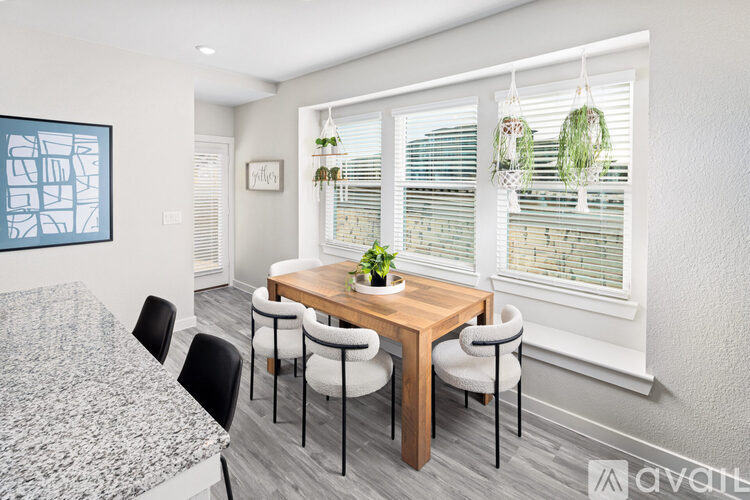 A dining room with a table and chairs.