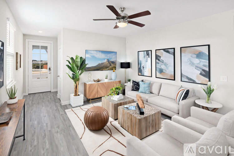 A living room with a grey couch, a wooden coffee table, and a painting on the wall.