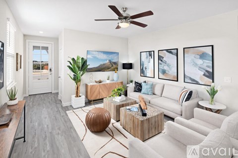 A living room with a grey couch, a wooden coffee table, and a painting on the wall.