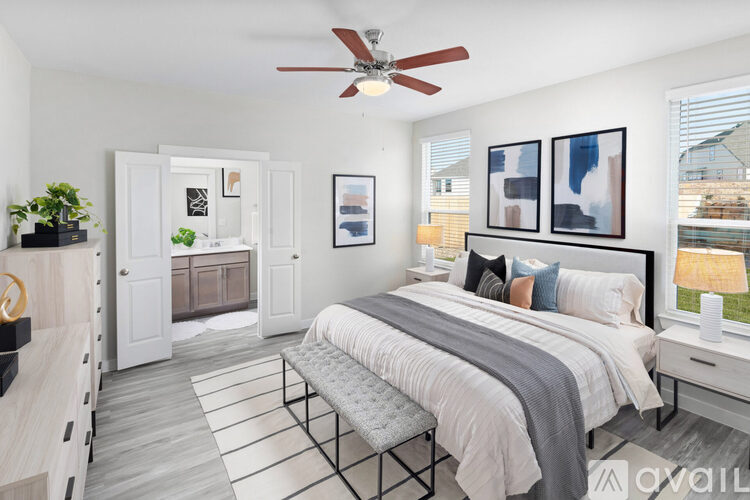 A bedroom with a large bed and a ceiling fan.