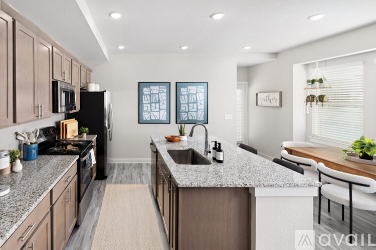 A kitchen with a black refrigerator and wooden cabinets.