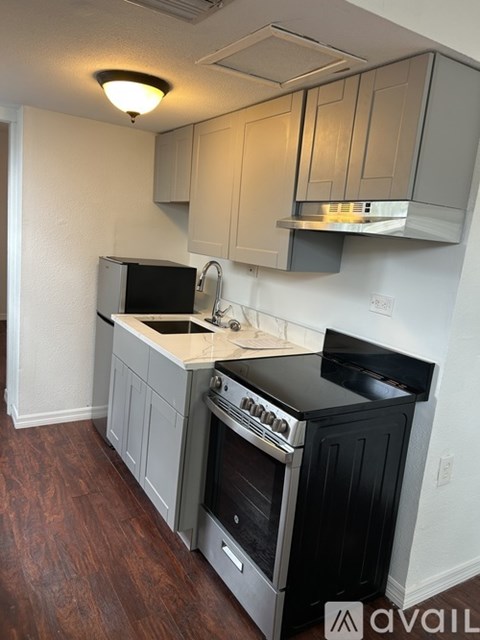 A kitchen with a black oven and wooden floors.