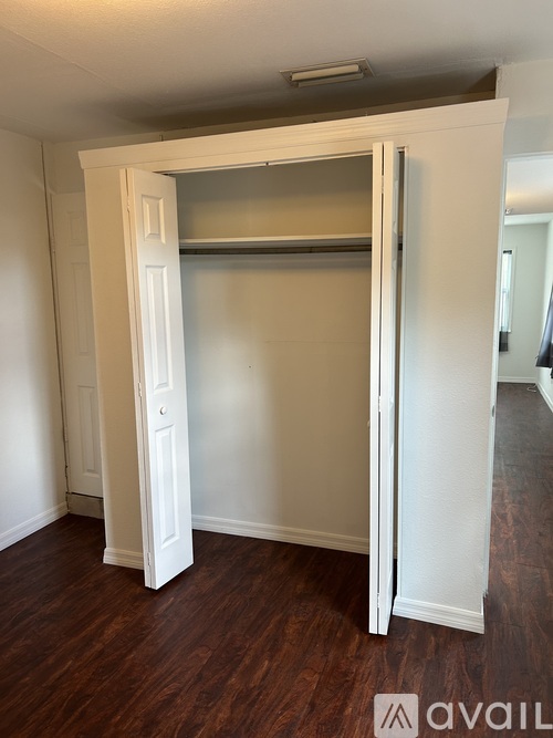 A white closet with a sliding door is open.