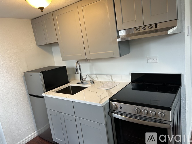 A kitchen with a black stove top oven and a black dishwasher.
