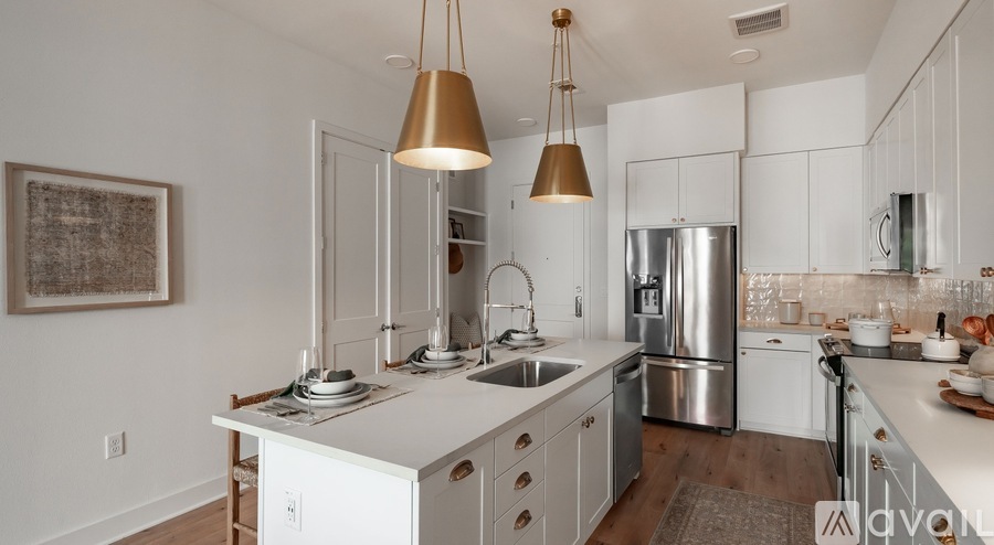 A modern kitchen with white cabinets and a stainless steel refrigerator.