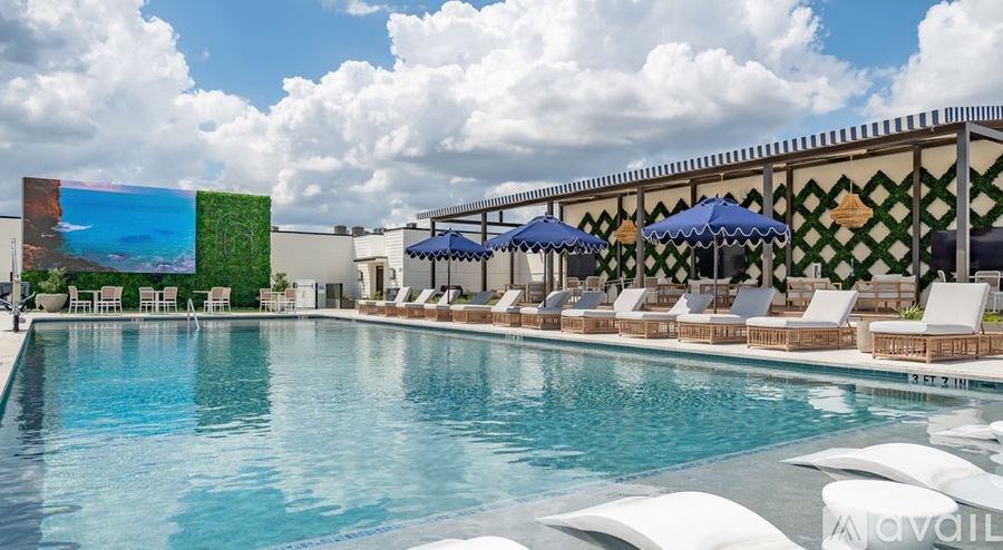A large swimming pool with lounge chairs and umbrellas.