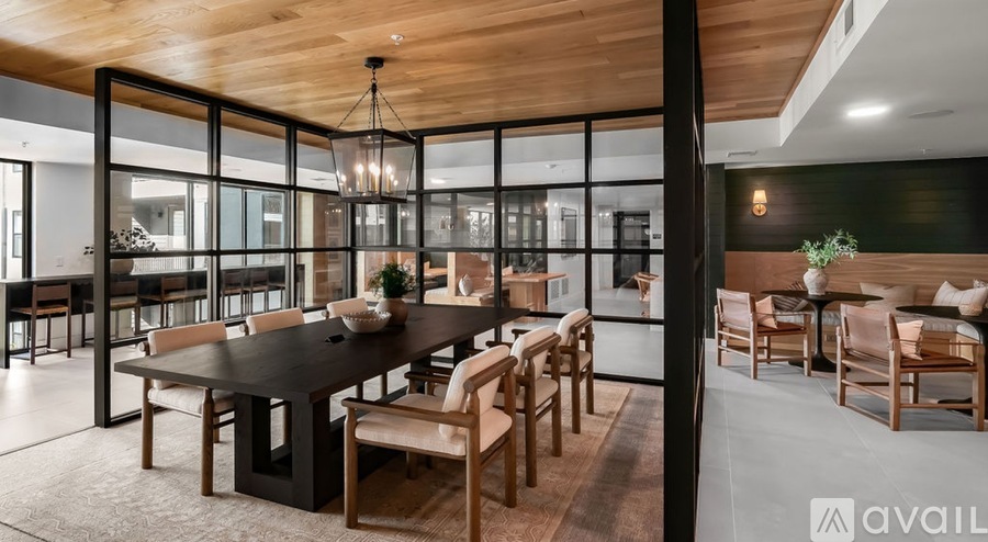 A modern dining room with a long table and chairs.