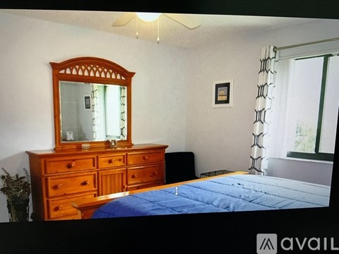 A bedroom with a bed, dresser, and mirror.