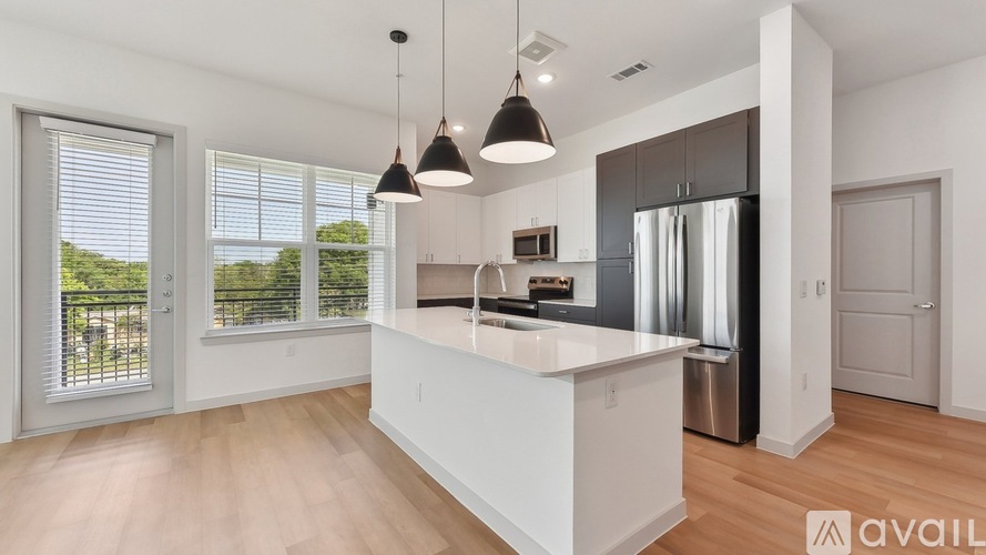 A modern kitchen with a large island and stainless steel appliances.