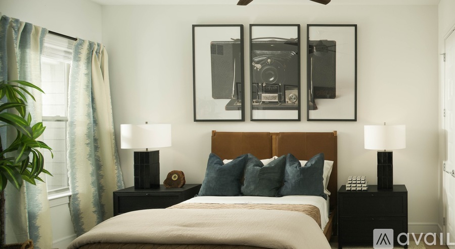 A bedroom with a bed, two lamps, and a framed picture on the wall.
