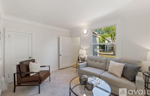 A living room with a brown chair and a grey couch.