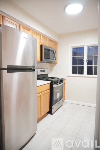 A kitchen with a stainless steel refrigerator and a microwave above the stove.