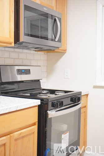 A modern kitchen with a stove top oven and microwave above it.
