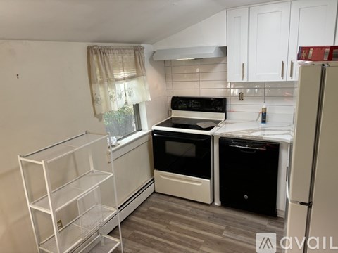 A kitchen with white cabinets and a black stove top oven.