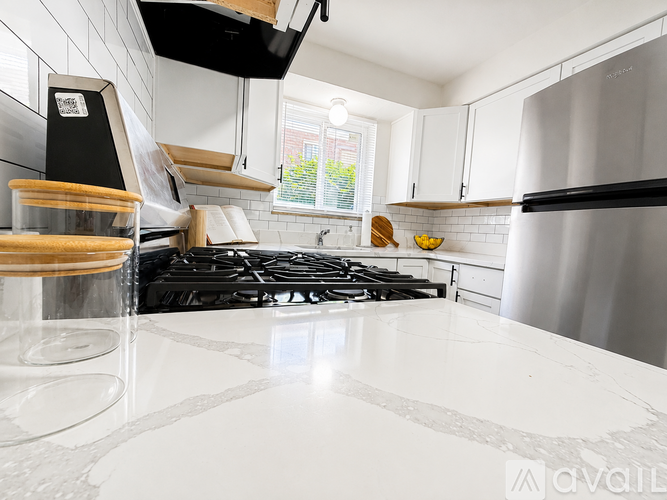 A kitchen with a white countertop and a black stove top.