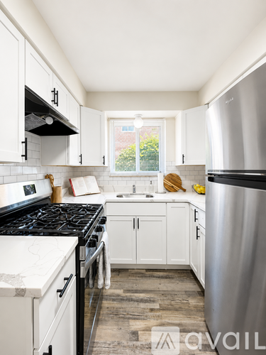 A kitchen with white cabinets and a stainless steel refrigerator.
