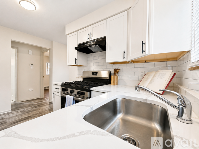 A kitchen with white cabinets and a stove top oven.