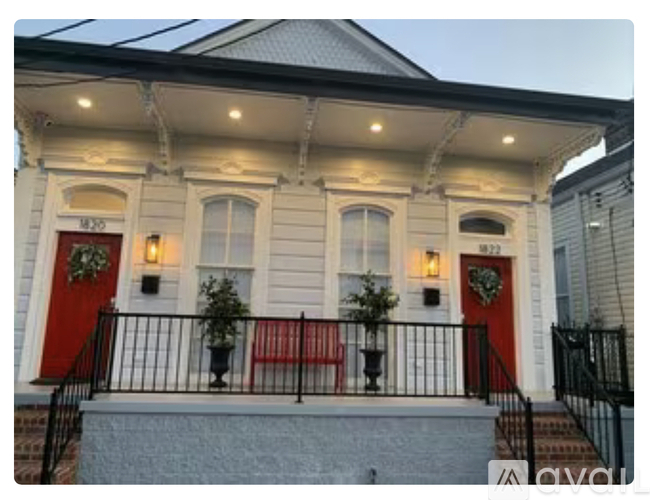 A white house with red doors and windows.