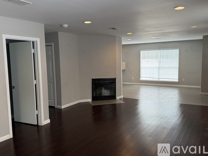 A spacious living room with a fireplace and hardwood floors.