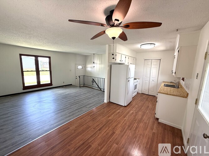 A room with a ceiling fan and wooden flooring.