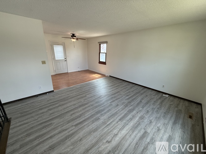 A room with wooden flooring and a ceiling fan.
