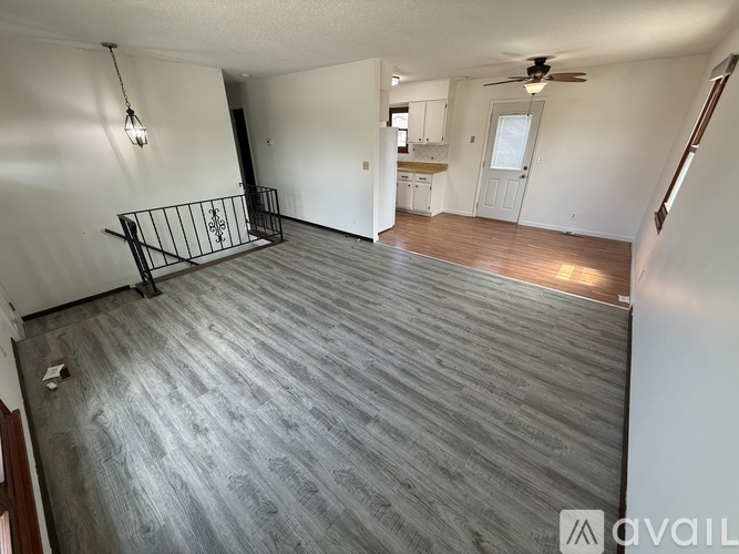 A spacious room with a grey floor and a ceiling fan.