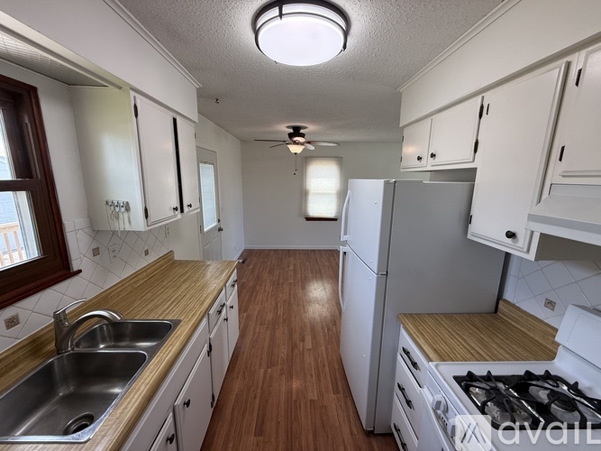 A kitchen with white cabinets and a wooden countertop.