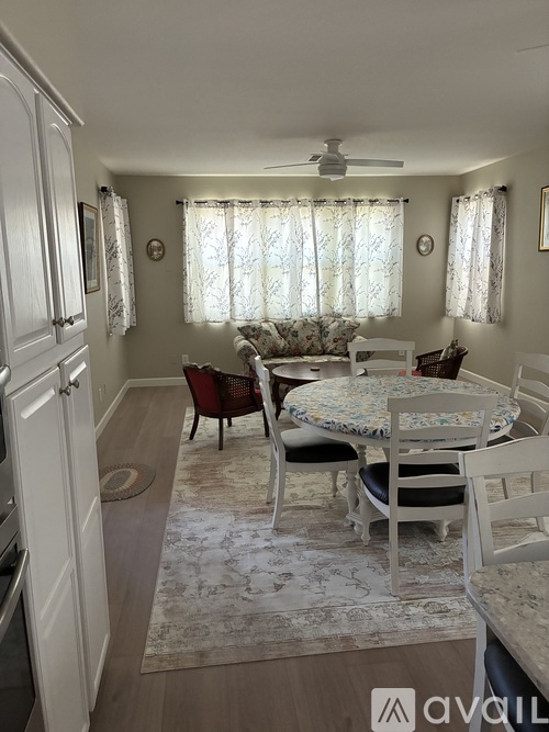 A dining room with a round table and chairs.