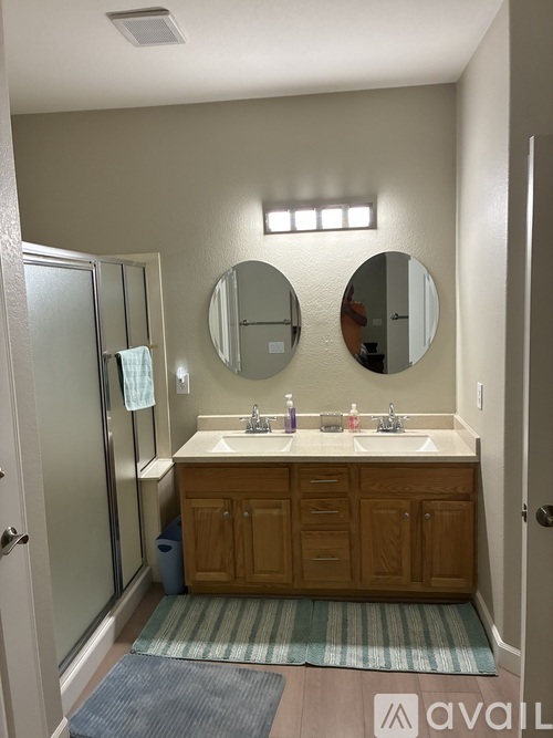 A bathroom with a sink, mirrors, and a cabinet.