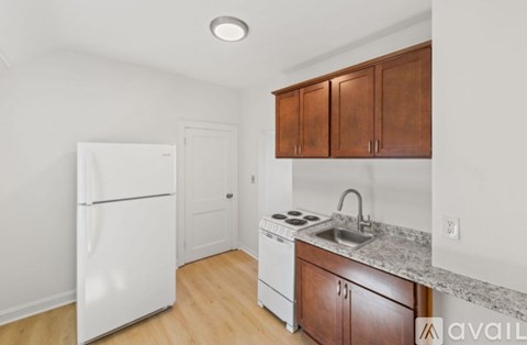 A kitchen with white appliances and wooden cabinets.