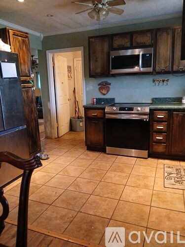 A kitchen with wooden cabinets and a tile floor.