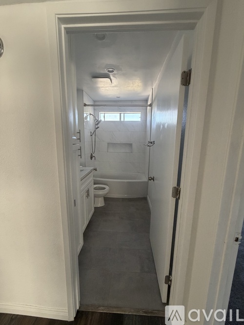 A white hallway with a toilet and a sink.