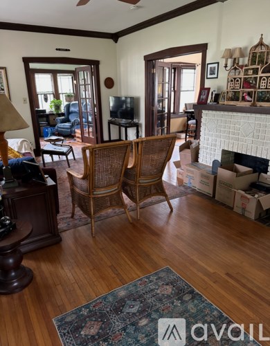 A living room with a fireplace and a rug on the floor.